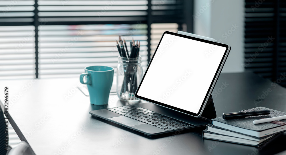 Fototapeta premium Mockup blank screen tablet with keyboard on black top table in modern office.