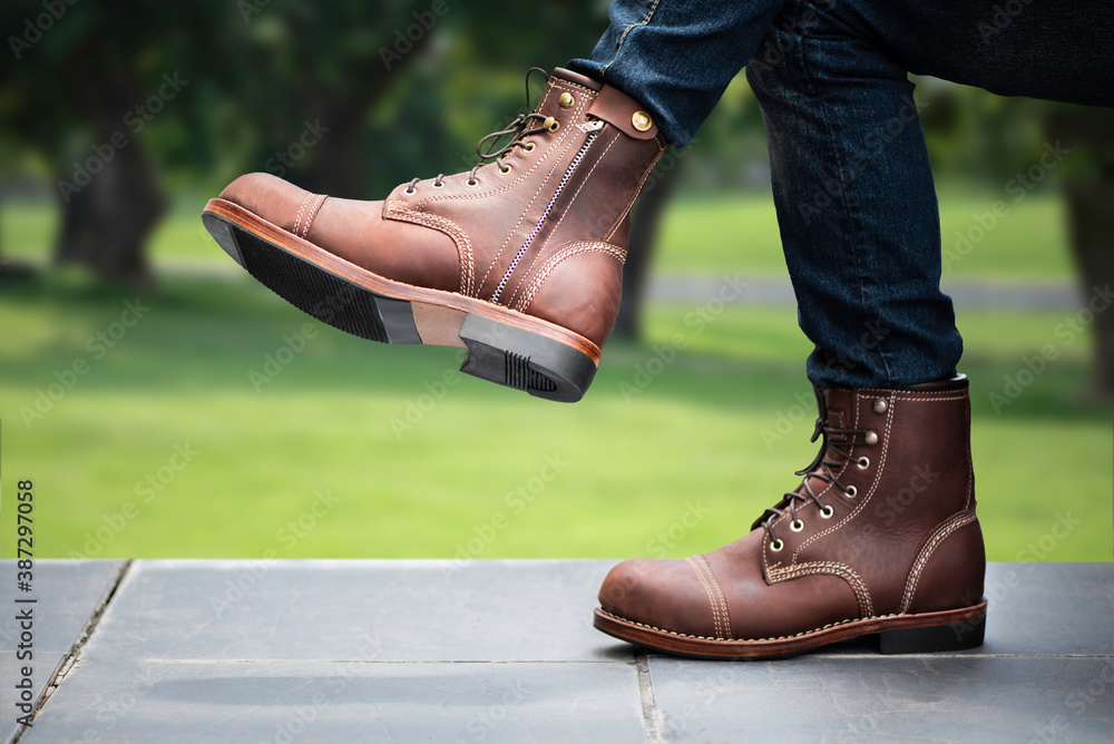 Fashion men s legs in blue jeans and brown boots with zipper for man collection. Stock Photo