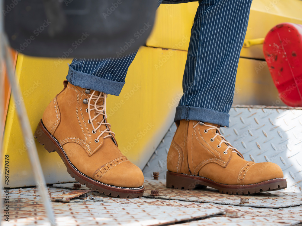 Fashion men in blue pants and yellow boots with zipper for man collection. Adobe Stock
