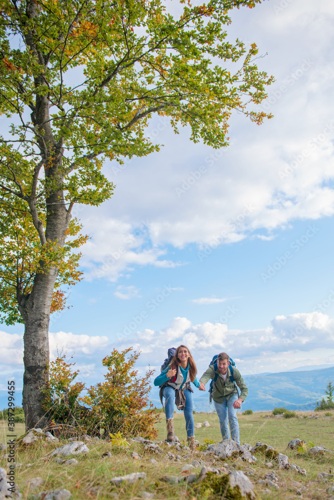 Happy couple hiking and enjoying a valley view Happy couple hiking and enjoying a valley view
