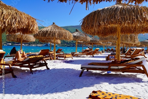 Fototapeta Naklejka Na Ścianę i Meble -  Bodrum, Turkey - August, 2020: Snow-white beach of Lux Hotel with emerald water of Aegean Sea. Yachts.People sunbathing on the beach. Sunbeds on the beach. Relaxing Deluxe Leisure Conception