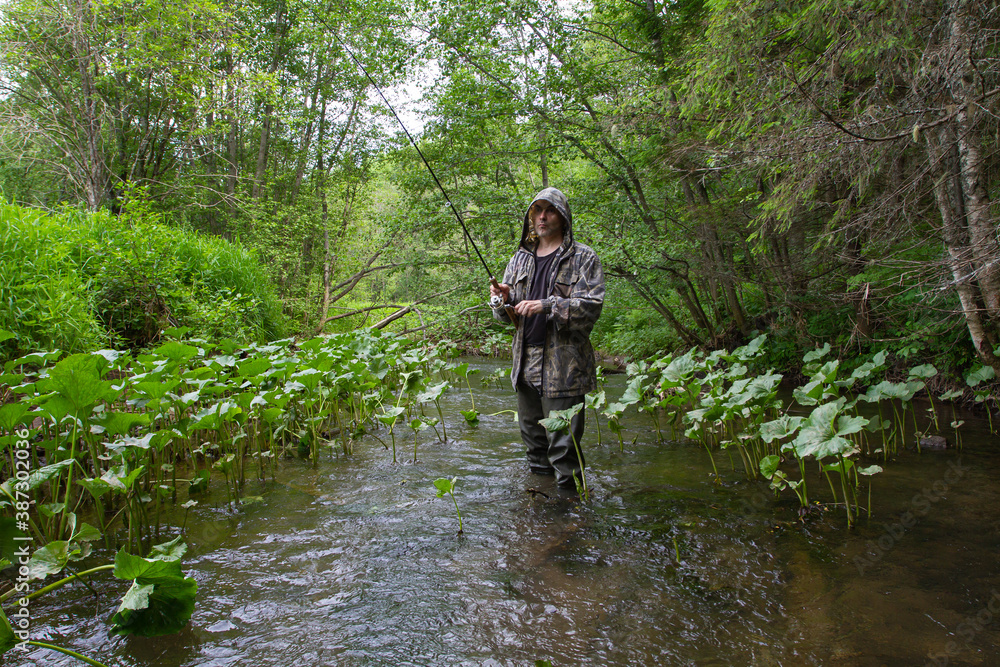 a man is fishing on the northern forest river