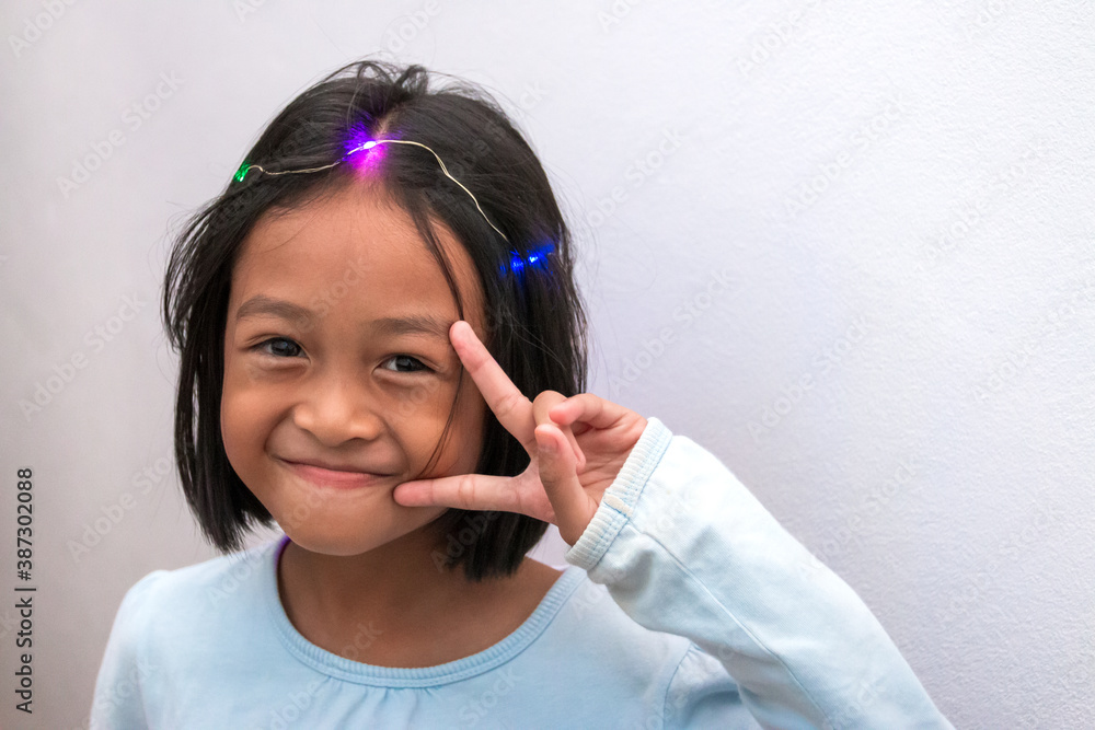 Portrait of a cute girl, smiling, cheerful, with bright lights on her head. Portrait of a cute girl, smiling, cheerful, with bright lights on her head.