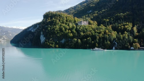 Ferry Boat Cruising On The Turquoise Blue Water Of Lake Brienz Near The Giessbach Waterfall In Brienz, Switzerland.  - aerial drone shot photo