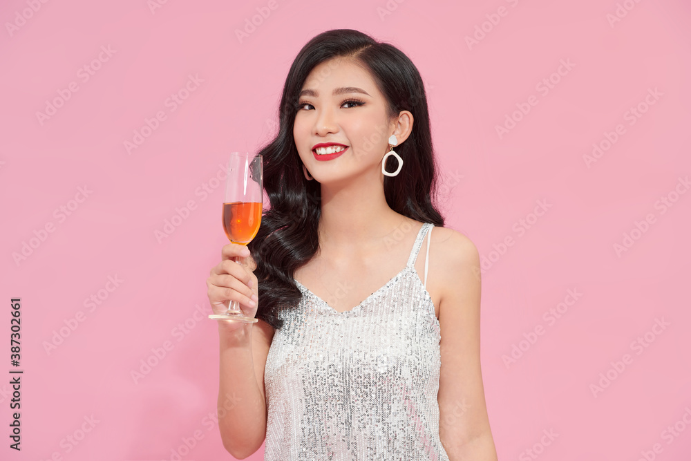 Good-looking asian girl in stylish attire standing in confident pose with wineglass on pink background. Good-looking asian girl in stylish attire standing in confident pose with wineglass on pink background.