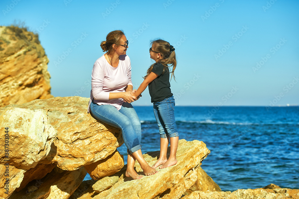 Mother and daughter on the sea coast on an autumn day