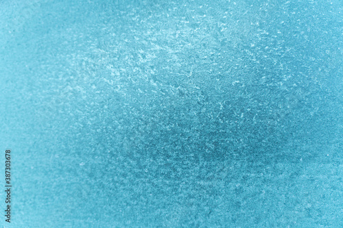 Frozen glass of the car. The patterns on the side car glass. Winter texture background. Frozen window of the car.