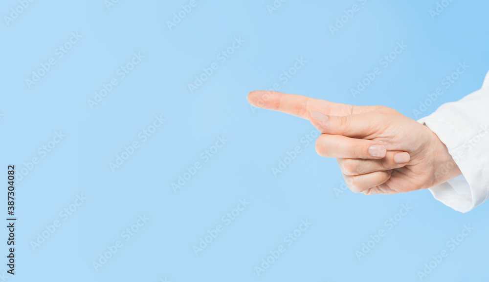 Female Doctors hand with finger pointing at copy space. Blue background. Medicine and healthcare concept. Announcement or message mockup template. Female Doctors hand with finger pointing at copy space. Blue background. Medicine and healthcare concept. Announcement or message mockup template.