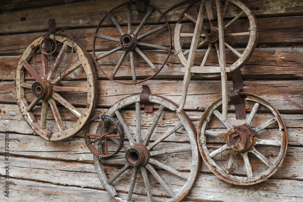 Wooden wheels from old carts on a shield made of wood as the story of village life.