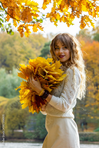 Beautiful girl with autumn leaves. October photos of autumn.