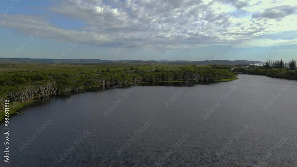 Stand-up Paddling At Lake Ainsworth - Tea Tree Water At The Northern End Of Pacific Parade In Lennox Head - NSW, Australia - ascending drone shot Stand-up Paddling At Lake Ainsworth - Tea Tree Water At The Northern End Of Pacific Parade In Lennox Head - NSW, Australia - ascending drone shot