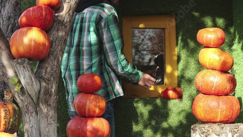 The man decorates the house with pumpkins.