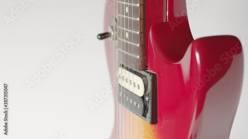 Rotating Cherry Burst Electric Guitar Close Up - Shallow Depth of Field.  Focus on strings over pickup.