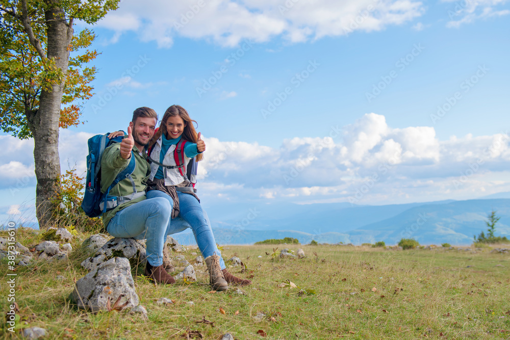 Couple Sitting On A Rock Resting During Hike Couple Sitting On A Rock Resting During Hike