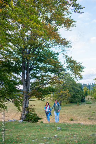 Couple of travelers with backpacks hiking in forest © FS-Stock