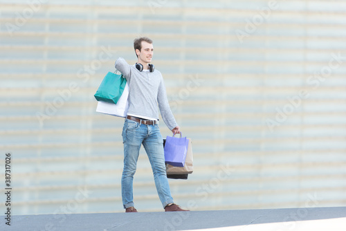 A young handsome man holding shopping bags.