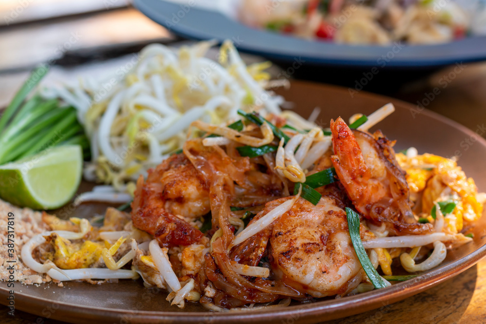 Pad Thai, Traditional stir-fried rice noodle dish commonly served as a street food and at most restaurants in Thailand as part of the country's cuisine. Stir fry noodles with sweet savoury sour sauce. Pad Thai, Traditional stir-fried rice noodle dish commonly served as a street food and at most restaurants in Thailand as part of the country's cuisine. Stir fry noodles with sweet savoury sour sauce.