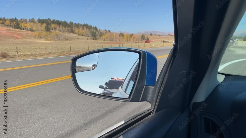 View of Police car in side mirror with lights flashing. Car pulled over for ticket. View of Police car in side mirror with lights flashing. Car pulled over for ticket.