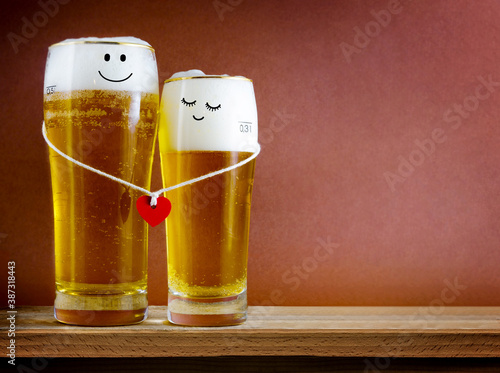 Fotografia Two glasses of beer with Painted happy couple and red heart on bar counter