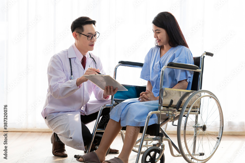 Male doctor giving information to female patient on wheelchair. Doctor explaining details to patient. Doctor giving a consultation to a patient and explaining medical information and diagnosis. Male doctor giving information to female patient on wheelchair. Doctor explaining details to patient. Doctor giving a consultation to a patient and explaining medical information and diagnosis.