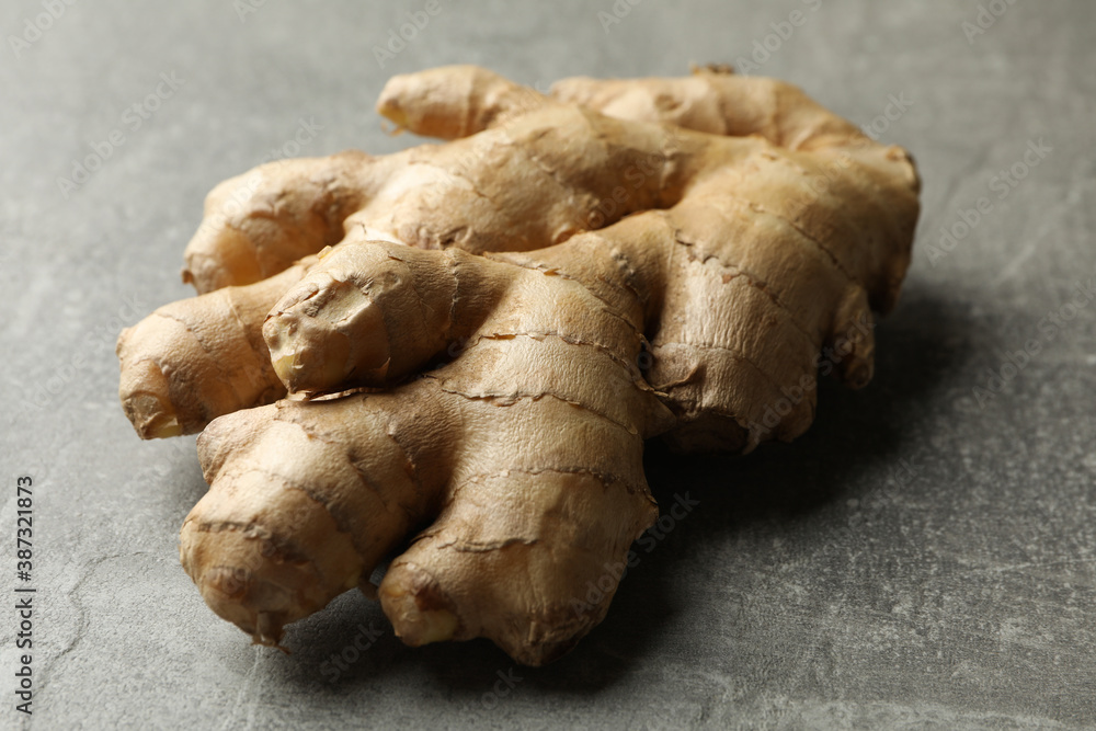 Fresh raw ginger on gray background, close up