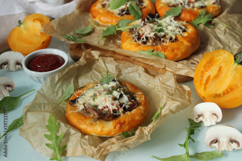 Delicious pastries with mushrooms and meat and decorated with cheese and herbs close-up