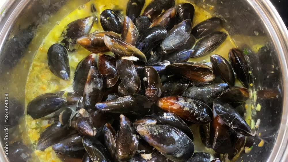 Steaming mussels in white wine cream stock in a pot Steaming mussels in white wine cream stock in a pot