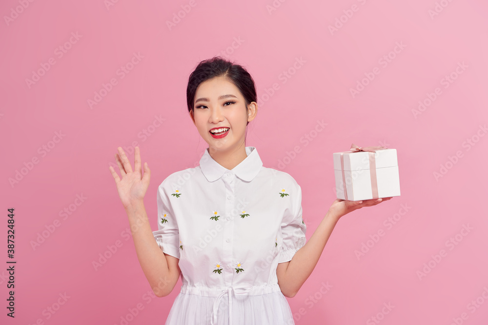 Picture of happy asian girl child standing isolated over pink background. Looking camera holding gift box surprise. Picture of happy asian girl child standing isolated over pink background. Looking camera holding gift box surprise.