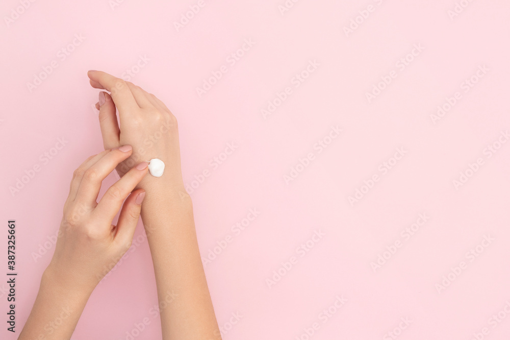 Hands with cream on a light pink background. Hands with cream on a light pink background.