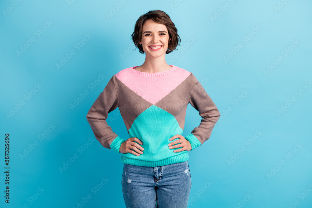 Photo portrait of smiling woman with hands on waist isolated on pastel light blue colored background Photo portrait of smiling woman with hands on waist isolated on pastel light blue colored background