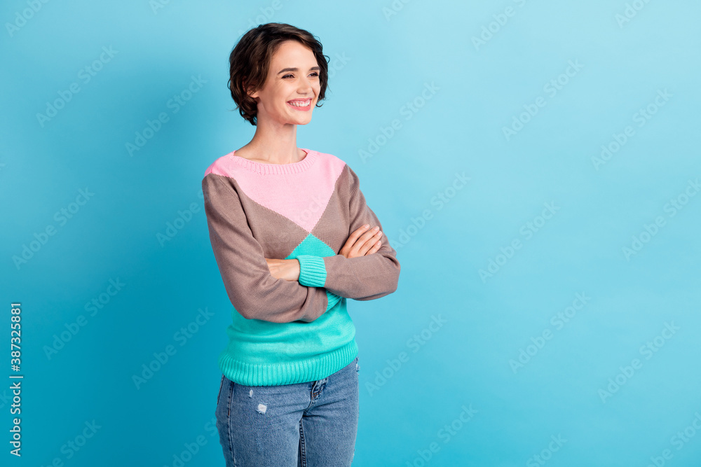Photo portrait three fourths 3 4 angle of woman with crossed arms smiling isolated on pastel light blue colored background Photo portrait three fourths 3 4 angle of woman with crossed arms smiling isolated on pastel light blue colored background
