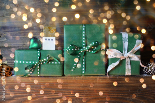 Christmas gift box on rustic wooden background with golden bokeh lights - Christmas greeting card