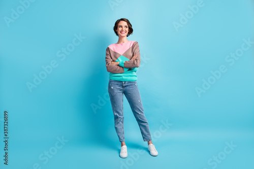 Photo portrait full size of young woman with folded hands watching to side isolated on pastel light blue colored background