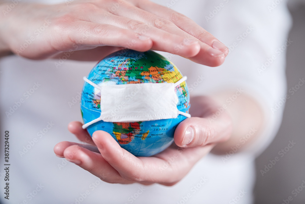 woman holding globe with protective mask woman holding globe with protective mask