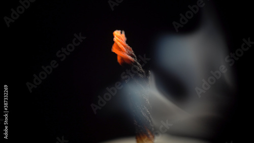 Fotografie Photo of smouldering candle wick on black background