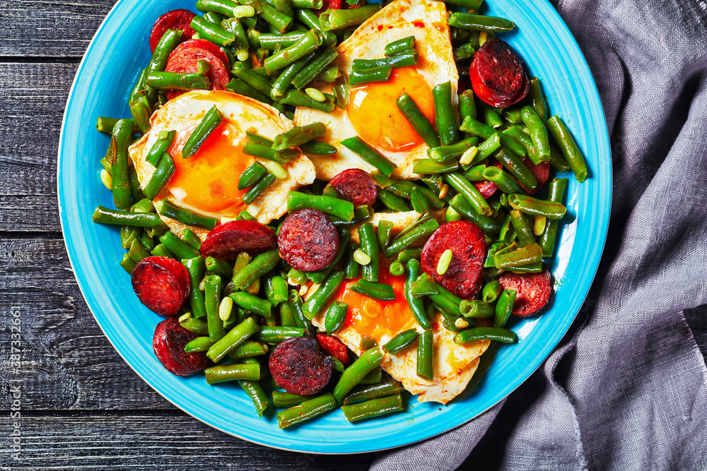 Green beans fried eggs and chorizo on a blue plate Green beans fried eggs and chorizo on a blue plate