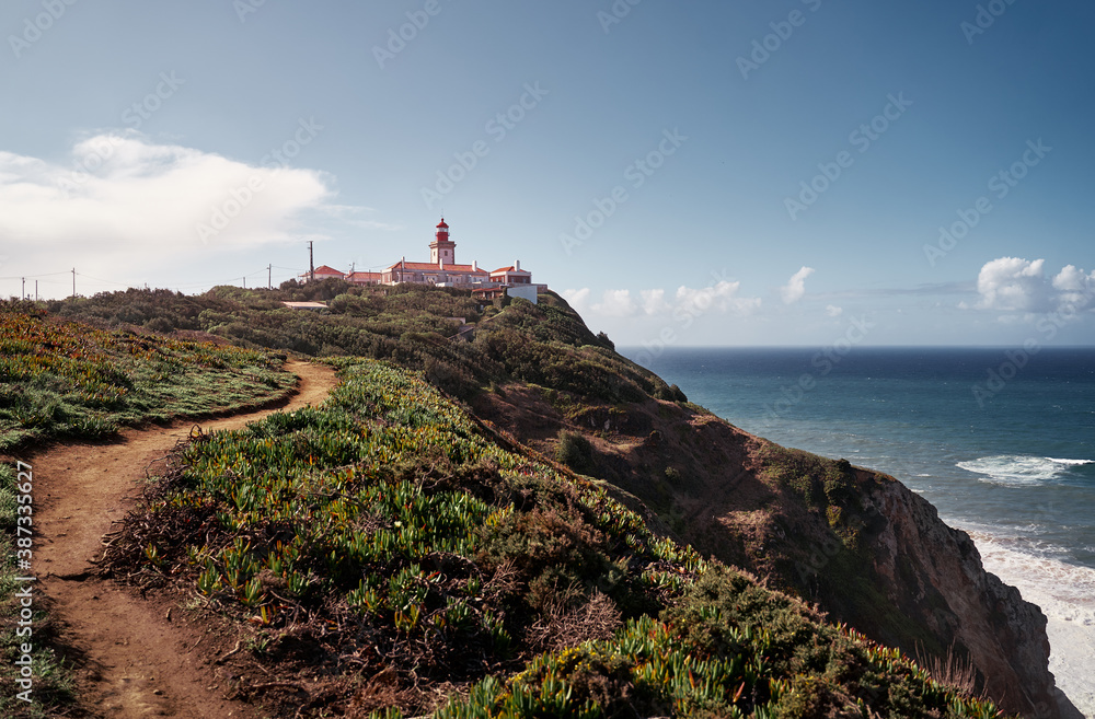 Famous lighthouse on Cabo da Roca, the western point of Europe. Beautiful landscape. Day time on the sea shore.