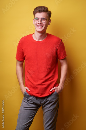 Studio portrait of happy handsome young man on yellow background.
