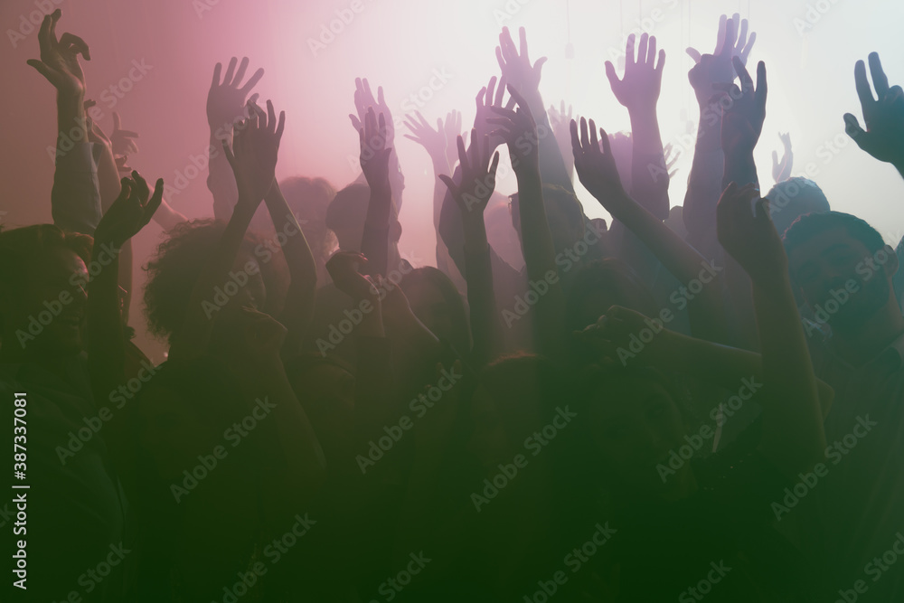 Photo of big company crazy people rise hands neon spotlight wear stylish trendy outfit modern club indoors
