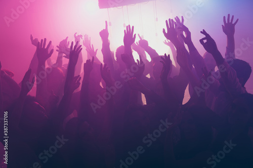Photo of big company many crazy people raise hands concert neon bright spotlight modern club indoors