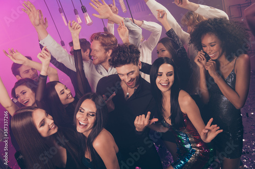 Photo of many cheerful people rise hands guy flirt girls laugh wear stylish outfit modern club indoors