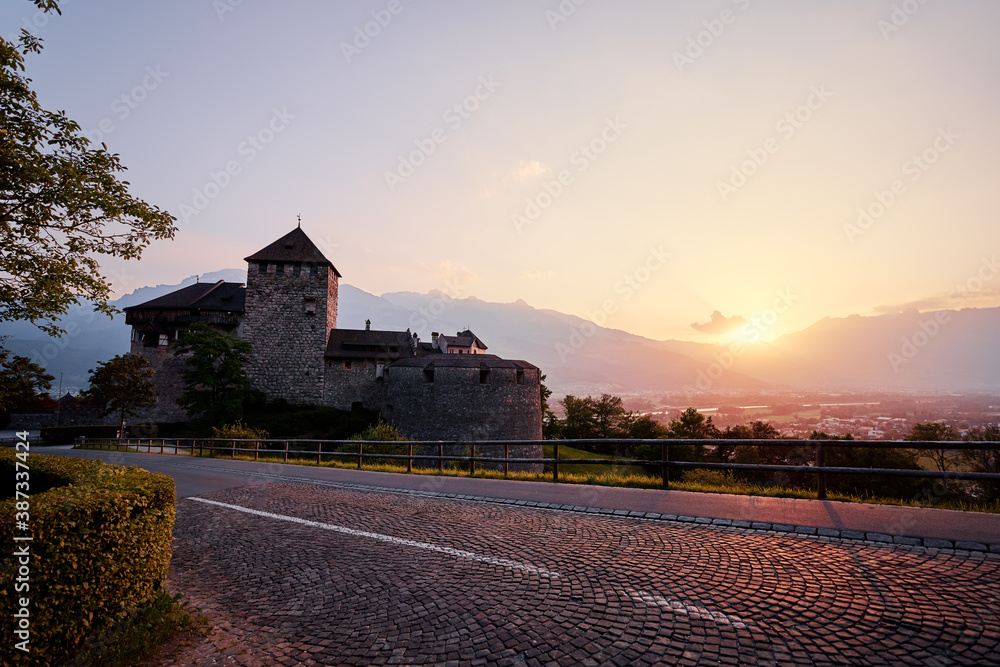Vaduz Castle, the official residence of the Prince of Liechtenstein, with Alps mountains in background on sunset.