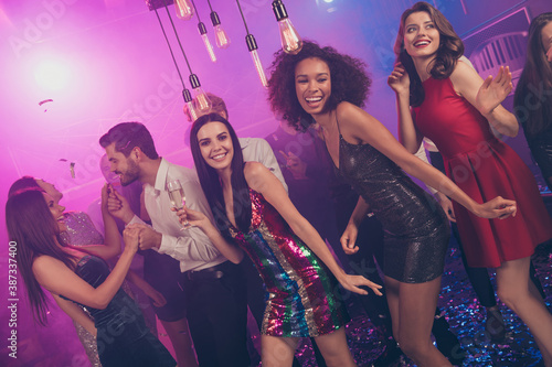 Photo of charming people have fun gorgeous girls champagne dance floor neon lights wear stylish outfit modern club indoors