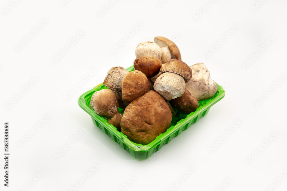 Beautiful fresh porcini mushrooms in green plastic basket on white background healthy food Beautiful fresh porcini mushrooms in green plastic basket on white background healthy food