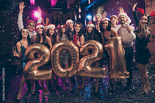 Photo portrait of happy people celebrating new year 2021 raising hands holding champagne glasses wearing goofy festive reindeer headwear
