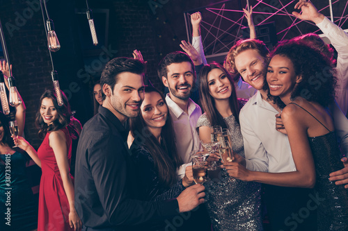 Photo of cheerful attractive people hold wineglass clink look camera wear stylish outfit modern club indoors