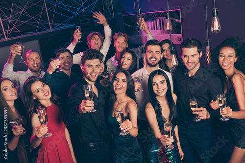 Photo portrait high angle of young people raising champagne glasses celebrating new year at club