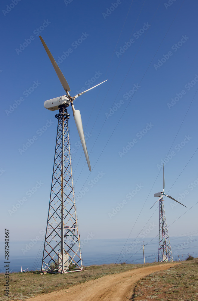 Mountain Wind Generators Along The Road On The Background Of The Sea Mountain Wind Generators Along The Road On The Background Of The Sea