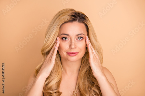 Photo of beautiful naked lady apply new anti age balm on perfect facial skin isolated pastel beige background