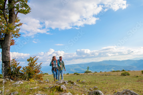 Happy couple hiking and enjoying a valley view